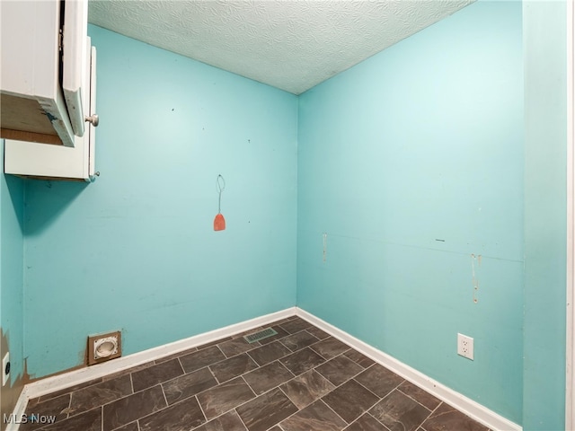 clothes washing area with electric dryer hookup and a textured ceiling