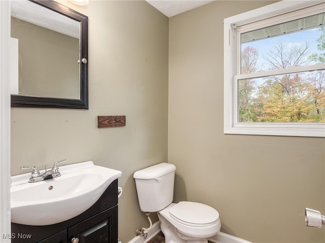 bathroom with vanity, a textured ceiling, and toilet