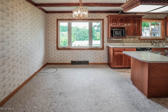 kitchen featuring light carpet, beam ceiling, decorative light fixtures, and sink