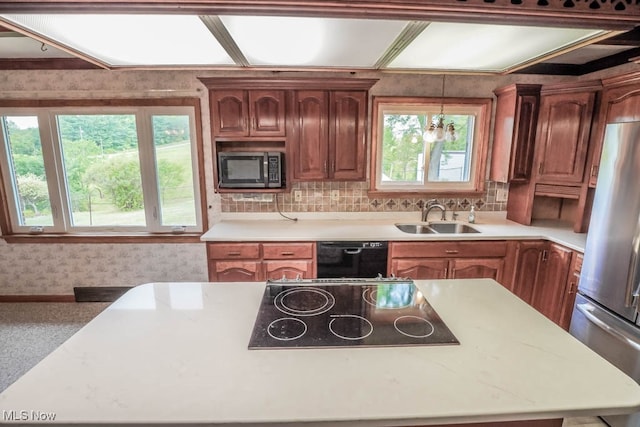 kitchen featuring black appliances, sink, decorative light fixtures, and an inviting chandelier