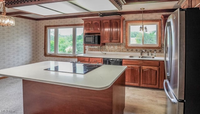 kitchen featuring decorative light fixtures, tasteful backsplash, black appliances, and sink