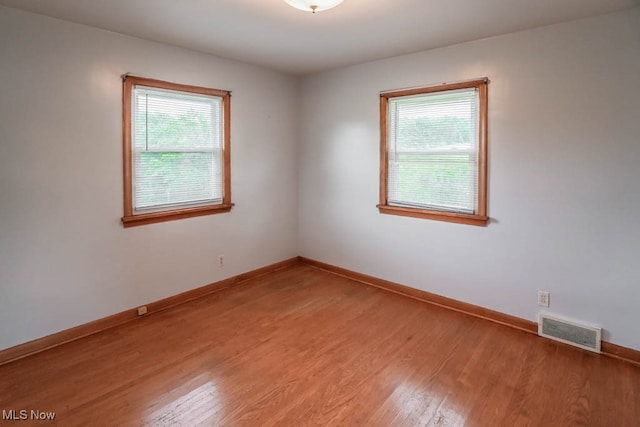 unfurnished room featuring a healthy amount of sunlight and wood-type flooring