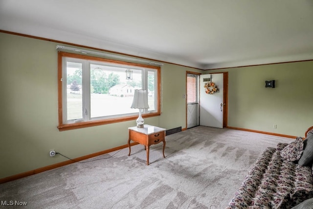 unfurnished room with ornamental molding and light colored carpet