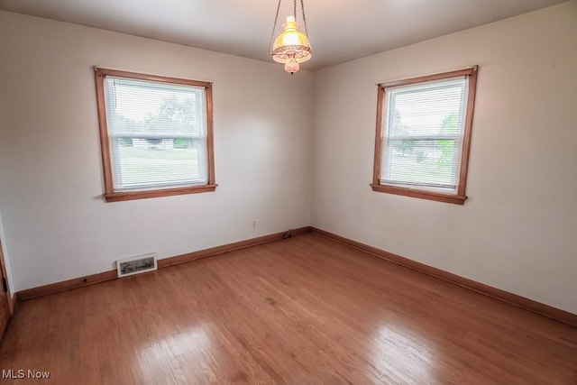 unfurnished room with hardwood / wood-style flooring and a wealth of natural light