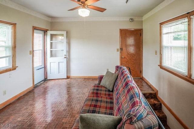 living room featuring crown molding, plenty of natural light, and ceiling fan