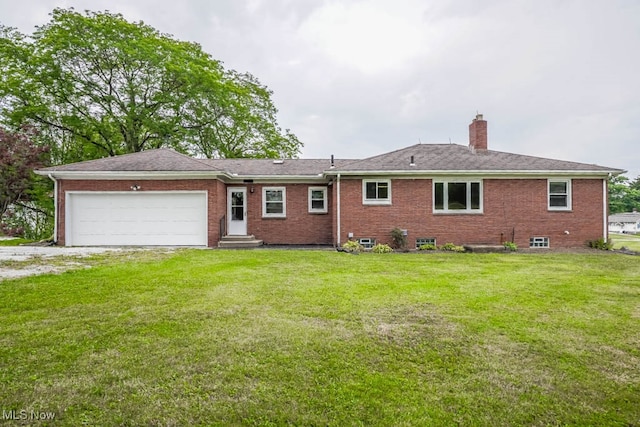 rear view of house with a lawn and a garage