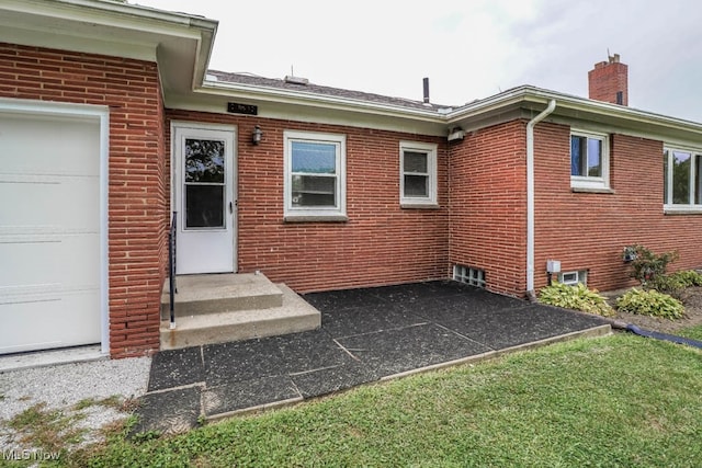 view of exterior entry featuring a yard