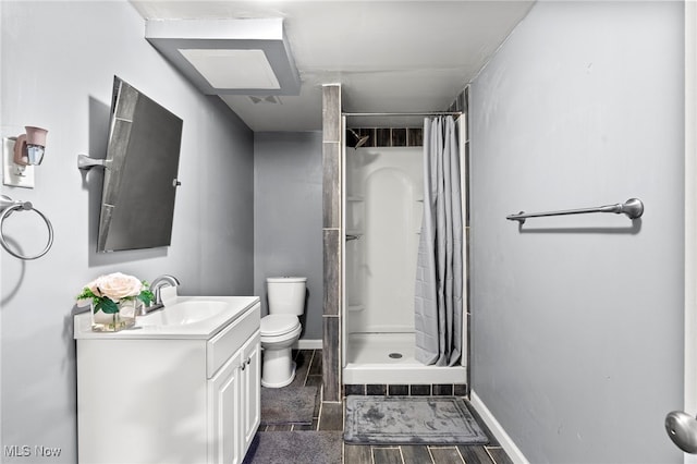 bathroom featuring vanity, toilet, a shower with shower curtain, and hardwood / wood-style floors