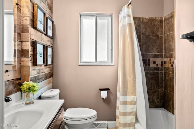 full bathroom featuring toilet, vanity, shower / bathtub combination with curtain, and plenty of natural light