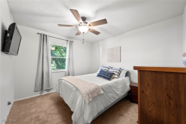 carpeted bedroom with a textured ceiling and ceiling fan