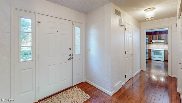 foyer entrance with dark wood-type flooring and a textured ceiling