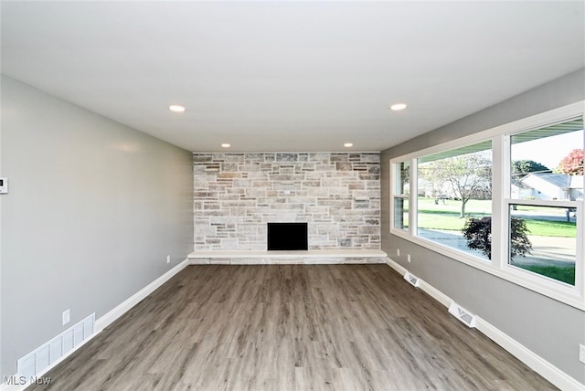 unfurnished living room with a fireplace and hardwood / wood-style flooring