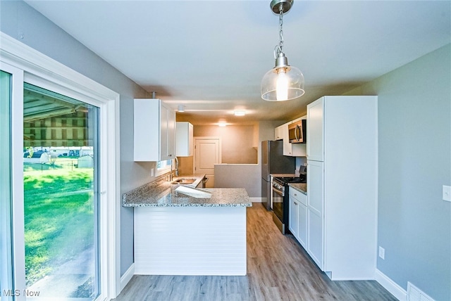 kitchen with kitchen peninsula, white cabinetry, light wood-type flooring, pendant lighting, and stainless steel appliances