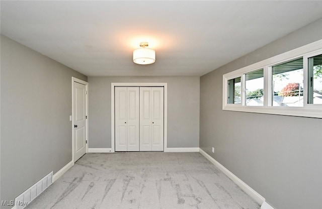 unfurnished bedroom featuring light carpet