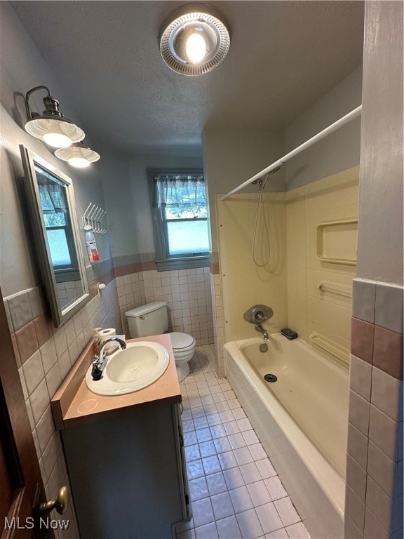 full bathroom featuring tile walls, toilet, shower / bath combination, vanity, and tile patterned flooring