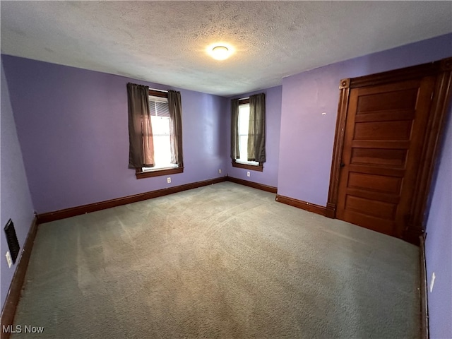 carpeted spare room featuring a textured ceiling