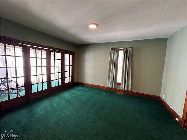 spare room featuring dark carpet