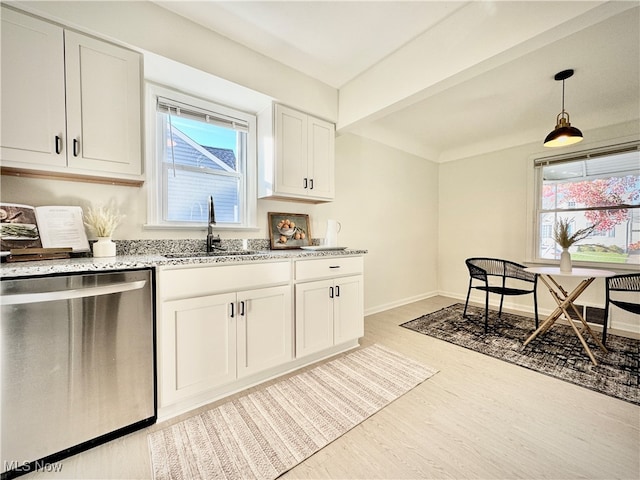 kitchen with hanging light fixtures, sink, stainless steel dishwasher, white cabinets, and light hardwood / wood-style floors