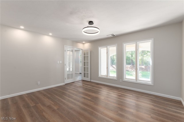 unfurnished room featuring french doors and dark hardwood / wood-style flooring