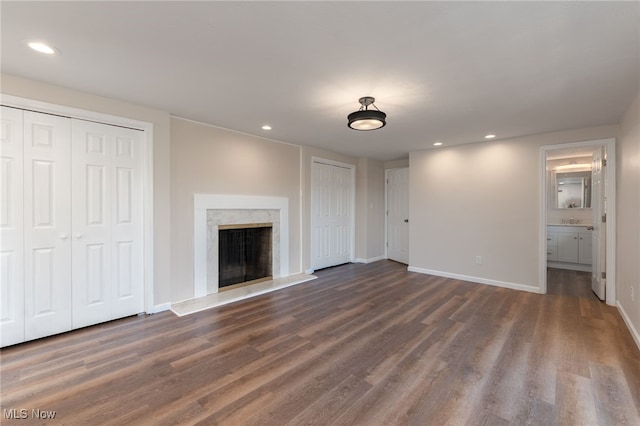 unfurnished living room featuring a high end fireplace and dark wood-type flooring