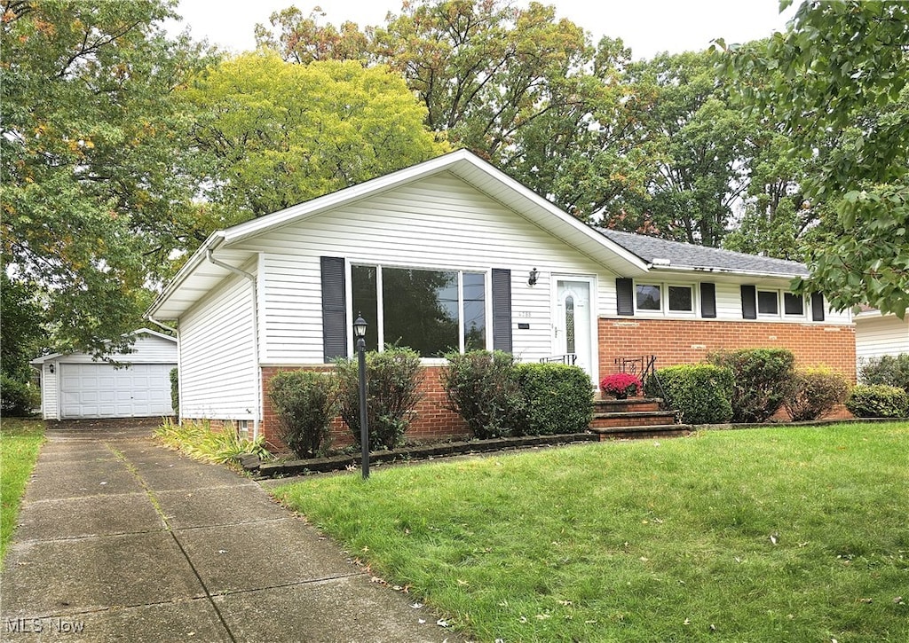 ranch-style home with a front yard, an outbuilding, and a garage