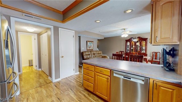 kitchen featuring stainless steel appliances, ornamental molding, ceiling fan, a textured ceiling, and light wood-type flooring