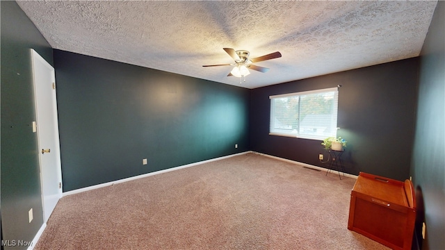 empty room featuring a textured ceiling, carpet flooring, and ceiling fan