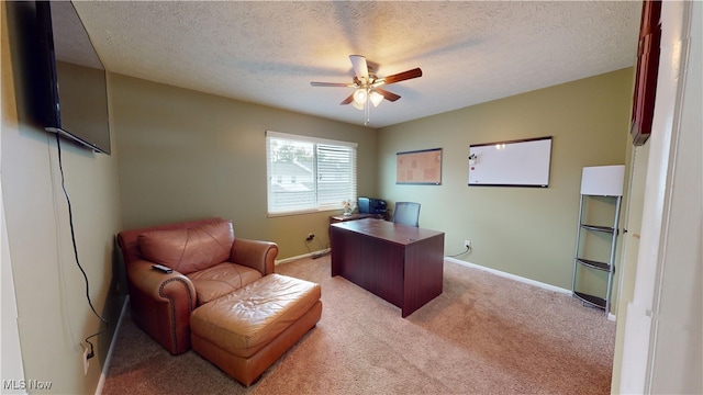 carpeted office space with a textured ceiling and ceiling fan