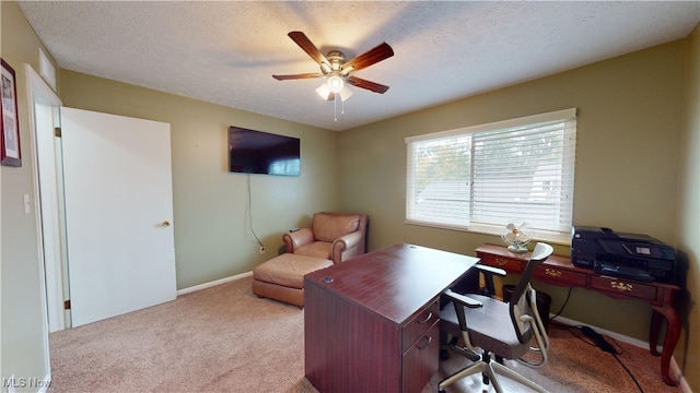 office featuring a textured ceiling, light colored carpet, and ceiling fan