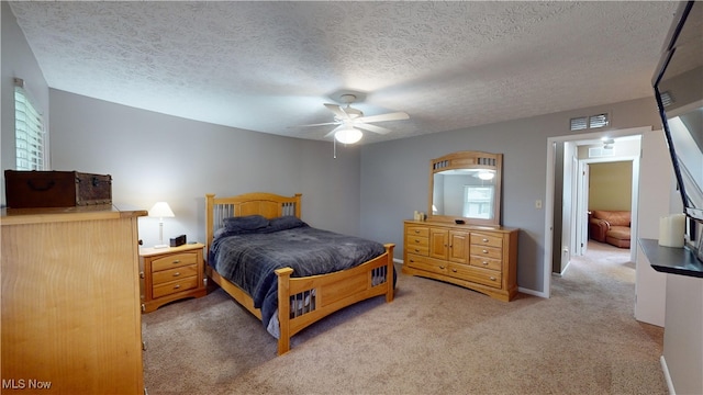 carpeted bedroom featuring a textured ceiling and ceiling fan