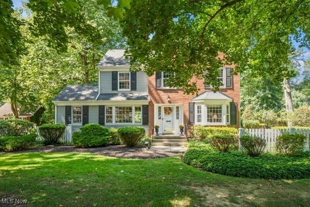 colonial house featuring a front lawn