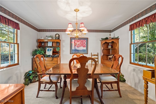 dining space featuring light colored carpet, plenty of natural light, and a notable chandelier