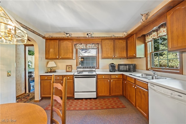 kitchen featuring dark colored carpet, white appliances, and sink