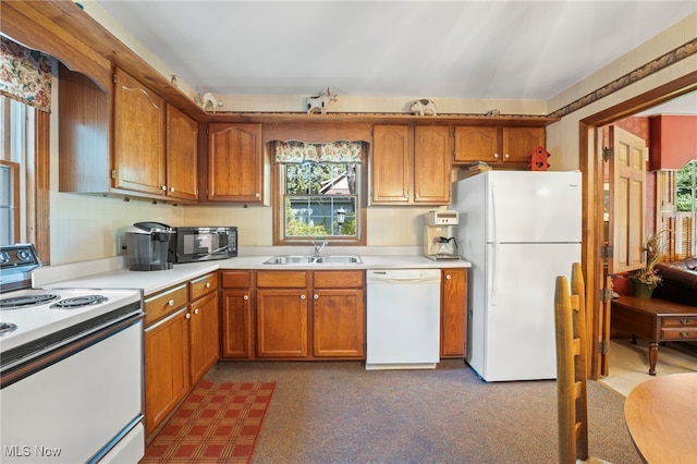 kitchen with sink, dark carpet, and white appliances