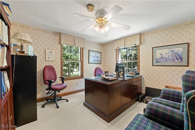 office area featuring a wealth of natural light, ceiling fan, and light carpet