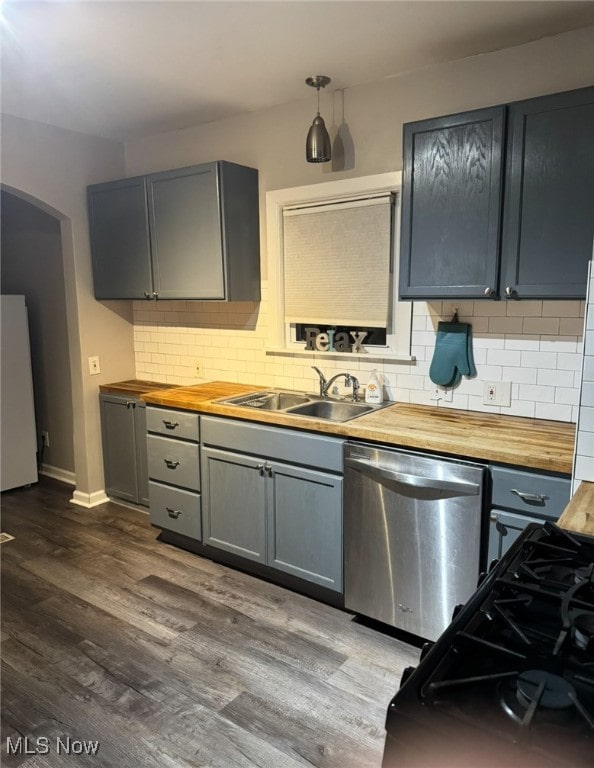 kitchen featuring wooden counters, sink, tasteful backsplash, dark hardwood / wood-style flooring, and stainless steel appliances