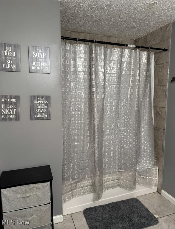 bathroom with tile patterned floors, a textured ceiling, and walk in shower