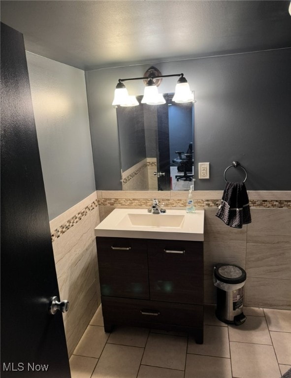 bathroom with tile patterned flooring, vanity, and tile walls