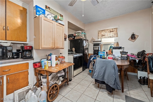 kitchen featuring a textured ceiling, ceiling fan, gas range gas stove, and light tile patterned floors