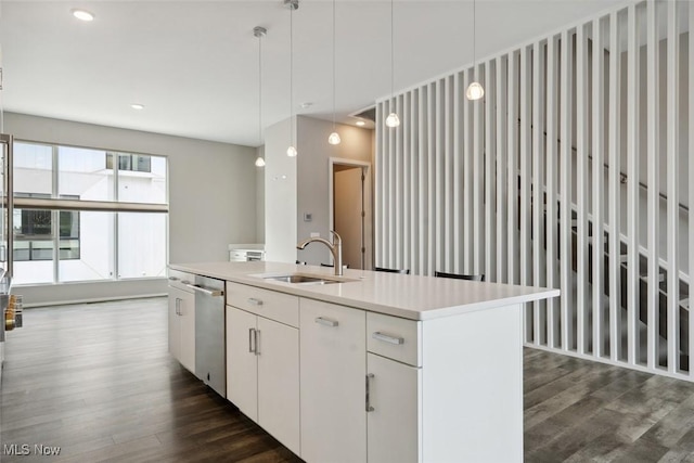 kitchen featuring dark wood finished floors, dishwasher, an island with sink, pendant lighting, and a sink