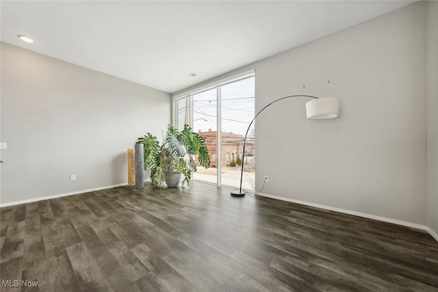 empty room featuring baseboards and wood finished floors