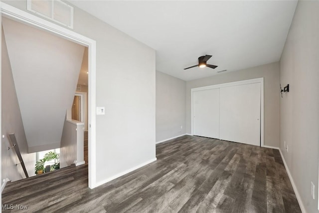 unfurnished bedroom with ceiling fan, wood finished floors, visible vents, baseboards, and a closet