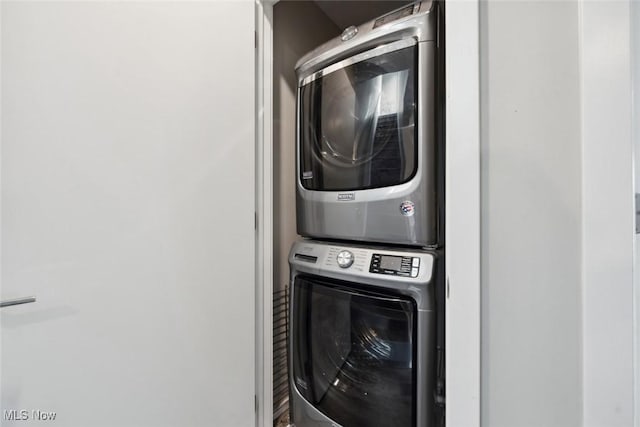 clothes washing area with laundry area and stacked washing maching and dryer