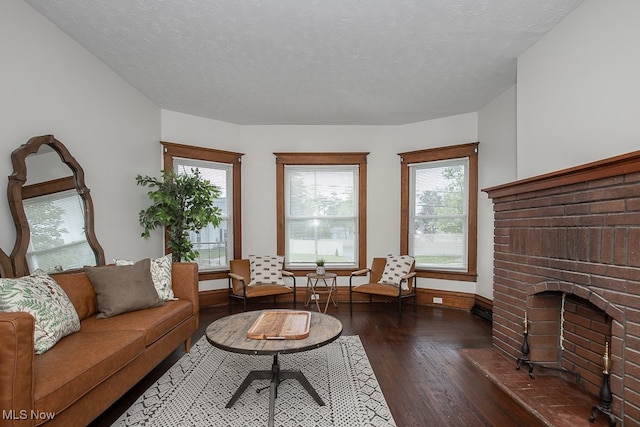 living room featuring dark hardwood / wood-style floors, a textured ceiling, and a wealth of natural light