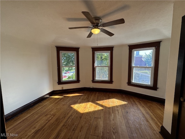 unfurnished room featuring dark wood-type flooring, a textured ceiling, and ceiling fan