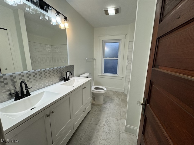 bathroom featuring toilet, tasteful backsplash, and vanity