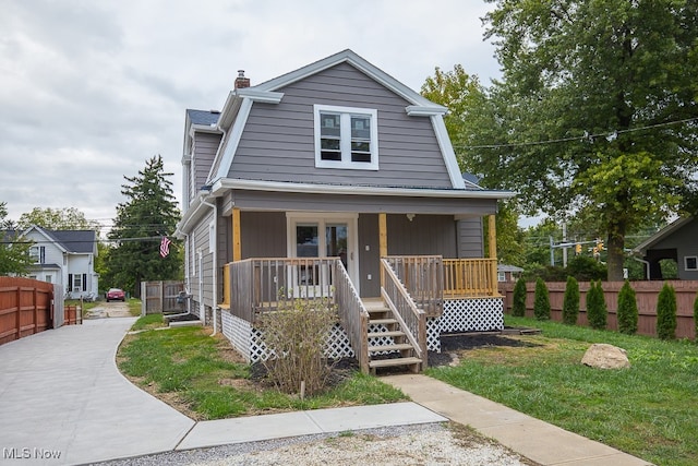 view of front of house featuring covered porch and a front lawn