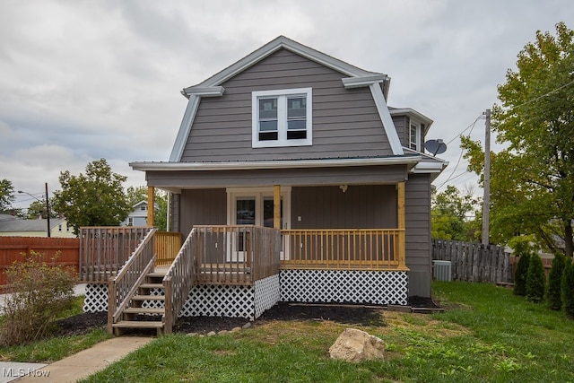 back of property with a porch, central AC, and a lawn