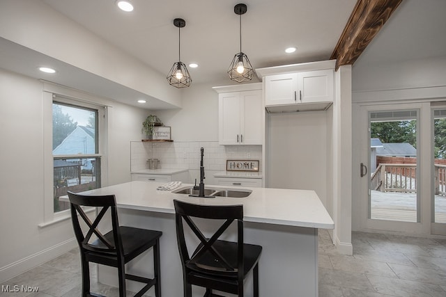 kitchen with white cabinetry, tasteful backsplash, sink, and a wealth of natural light