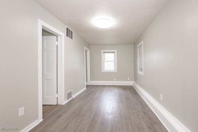 unfurnished room with hardwood / wood-style floors and a textured ceiling